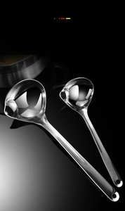 Detailed view of two stainless steel oil separator spoons with side pouring spouts