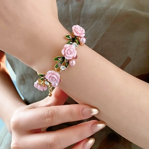 Détail du bracelet rose rose avec perles et cristaux sur une chaîne dorée fine