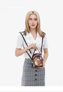 Detail of bohemian patchwork mini backpack with colorful patterns and golden heart charm