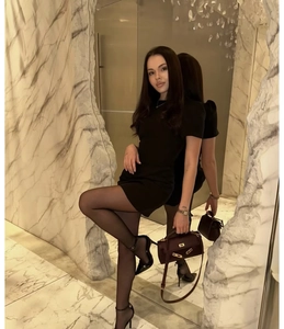 Artistic mirror reflection of a chic black puff sleeve mini dress and brown handbag