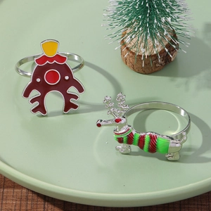 Close-up of enamel reindeer napkin rings in red and silver on a festive holiday table