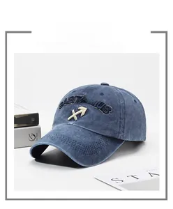 Detail of blue washed cotton baseball cap featuring Sagittarius embroidery and vintage finish