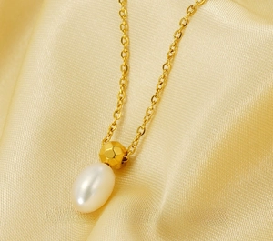 Detail of drop pearl pendant on a gold stainless steel chain with eco-friendly plating
