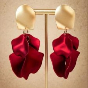 Boucles d'oreilles vintage en or mat et rouge foncé avec pétales sur support à bijoux