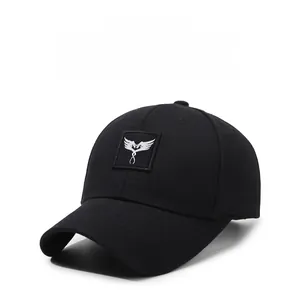 Detailed view of the white wing embroidery on a premium black cotton baseball cap