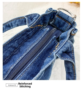 Detail of indigo denim bag featuring yellow reinforced stitching and metal zipper