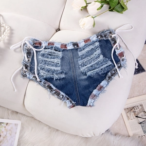 Dettaglio ravvicinato di pantaloncini di denim a vita bassa con lacci e bordi sfrangiati