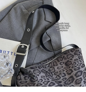 Detail of leopard print tote bag with wide leather strap and silver metal eyelets
