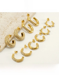 Detail of 18K gold-plated stainless steel earrings with rhinestones and pearls on stone