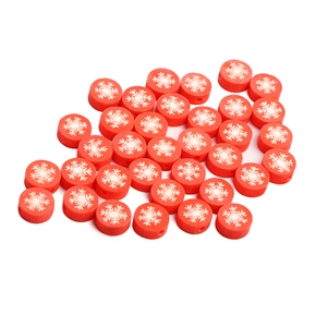 Close-up of red polymer clay beads with white snowflake patterns for DIY jewelry making