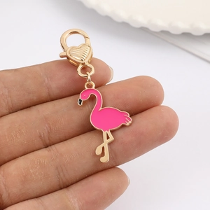 Detailed view of pink enamel flamingo charm with golden heart-shaped lobster clasp