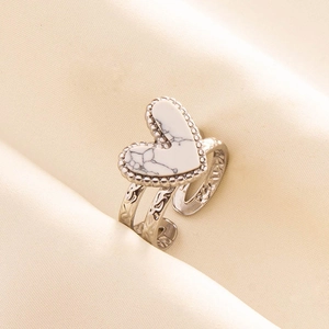 Detailed macro view of an antique-style silver heart ring with intricate vine carvings