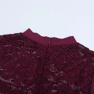Macro detail of burgundy lace collar with precision patterns and invisible zipper closure