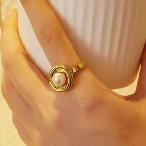 Detailed macro view of 18k gold plated stainless steel pearl ring worn on finger