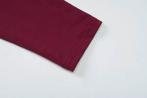 Detailed macro view of wine red knit dress cuffs showing neat double needle stitching