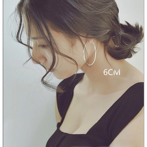 Pendientes de aro clásicos de acero inoxidable plateado de 6cm usados por una modelo de moda