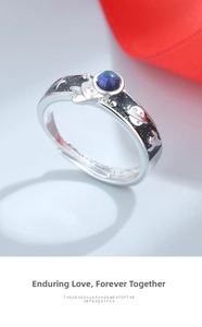 Detail of astronaut couple ring with blue sandstone inlay and celestial black oil dripping