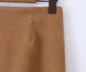 Close-up of the fine suede texture and waist dart stitching on the brown midi skirt
