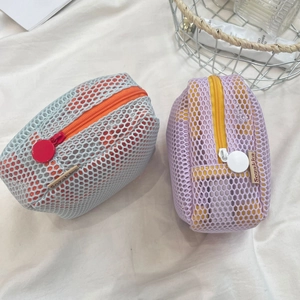 Detail view of colorful mesh makeup bags in blue-orange and purple-yellow contrasts