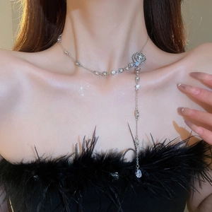 Macro view of crystal flower necklace with long tassels and teardrop pendant details