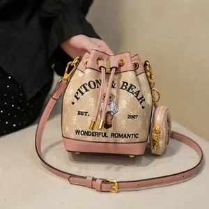 Pink and beige drawstring bucket bag with bear embroidery and matching mini pouch