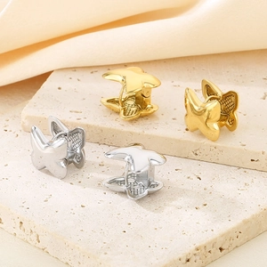 Detail of 3D butterfly earrings in gold and silver finish on elegant stone pedestals