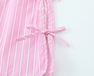 Detailed close-up of pink and white striped fabric with decorative side bow knot tie