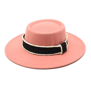 Detail of pink wool felt boater hat with black grosgrain ribbon and delicate white beads