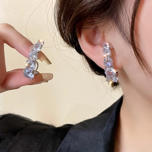 Boucles d'oreilles courbées en zircon géométrique avec tiges en argent sur modèle