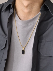 Men's gold cuban chain with black octagonal pendant shown on model for length and style
