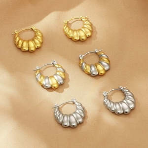 Vue détaillée des boucles d'oreilles en U dorées et argentées avec texture sur soie