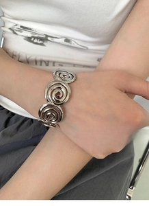 Detail of silver spiral open cuff bracelet showing geometric concentric patterns