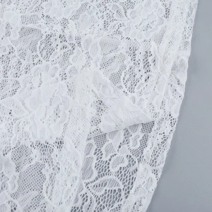 Primo piano del tessuto in pizzo floreale bianco che mostra intricati motivi a fiori