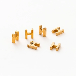 Macro shot of 1.8mm aperture gold-plated letter H beads for DIY jewelry making