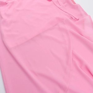 Close-up of light pink chiffon fabric showing soft ruffles and layered texture of the dress