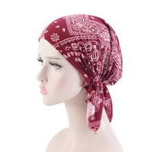 Detail of burgundy ethnic headwrap with paisley print showing pre-tied knot design