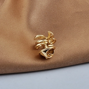 Detailed macro view of the gold flower brooch featuring crystal pave and needle pin clasp