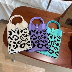Détail de mini sacs en tricot imprimé léopard en blanc, violet et vert