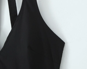Detail shot of the deep V-neckline and straps on a black backless halter dress