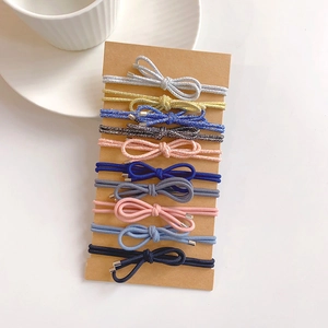 Detailed set of 10 glitter and solid elastic bow hair ties on a display card