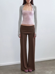 Détail d'un débardeur rose clair avec boléro en tricot gris et pantalon large marron