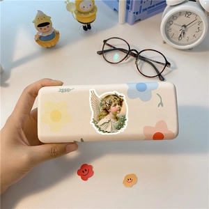 Close-up of a vintage-style cream glasses case with retro angel and floral art prints