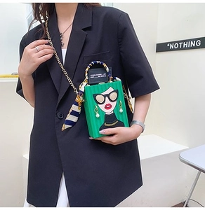 Close-up of green vintage box bag with portrait print and silk scarf handle detail