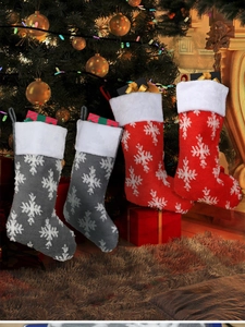 Detail of plush Christmas stockings in red and grey with large white snowflake patterns