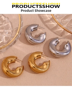 Detailed view of chunky C-shaped polished stainless steel hoop earrings in gold and silver