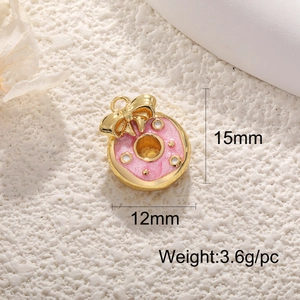 Dettaglio di un ciondolo a ciambella rosa glitterata con fiocco dorato e misure 15x12mm