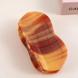 Classic amber acetate hair claw clip with modern checkered texture and large grip size