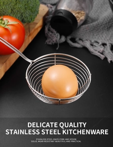 Close-up of stainless steel spider strainer holding eggs in a professional kitchen setup