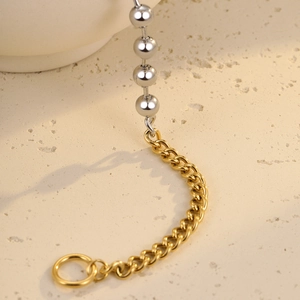Macro shot of two-tone stainless steel beads and Cuban chain link with OT ring closure