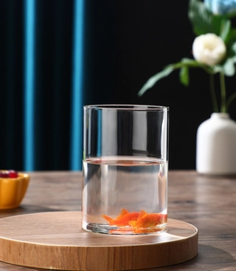 Macro shot of high-transparency cylindrical glass vase on a wooden base in home setting